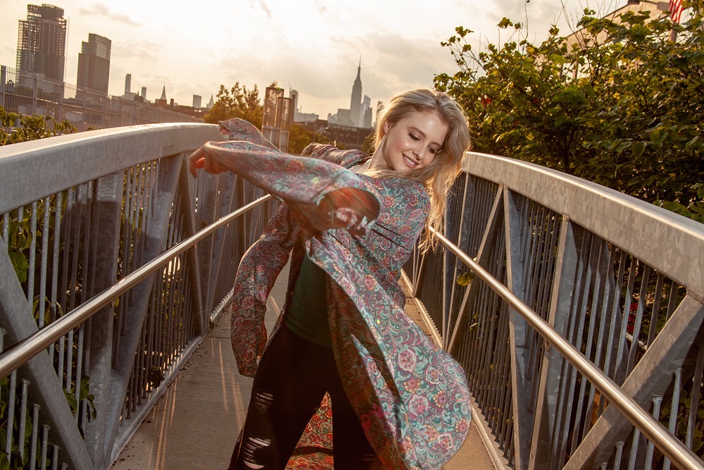 Jenilyn on a bridge with a paisley kimono and the skyline behind