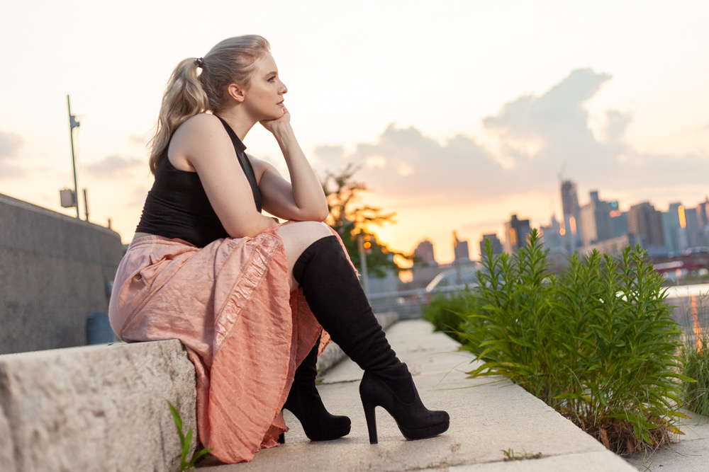 Jenilyn seated at sunset with the New York City skyline behind